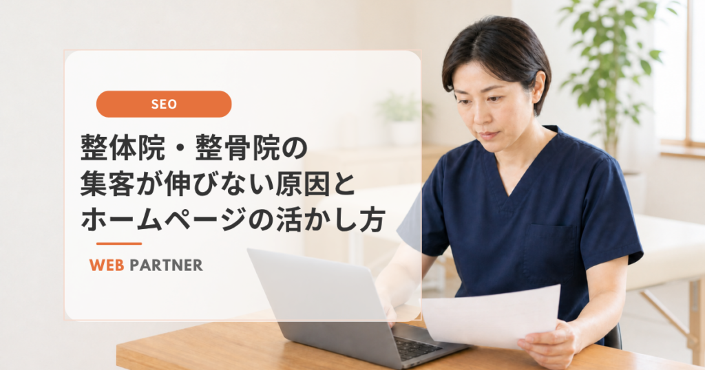 紺色のスクラブを着た整体院のスタッフが、ノートパソコンと書類を見ながらホームページの集客状況を確認している様子