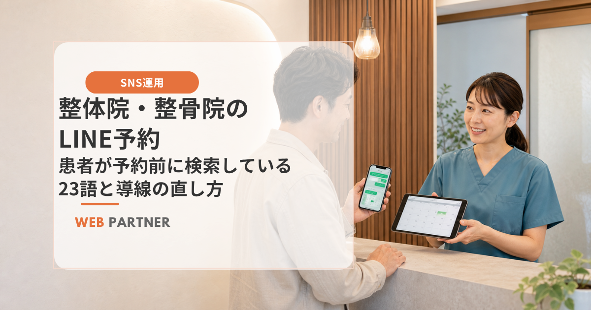 整体院・整骨院の受付で、患者がスマートフォンのLINE予約画面を見せ、整体師がタブレットで予約日時を確認している様子